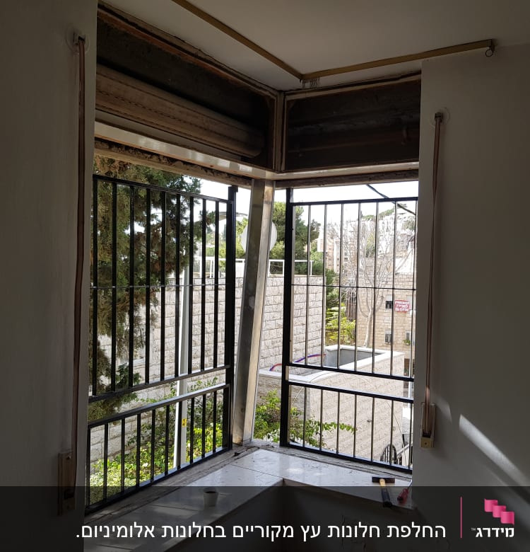 חלון עם מסגרת אלומיניום ותריסים פתוחים